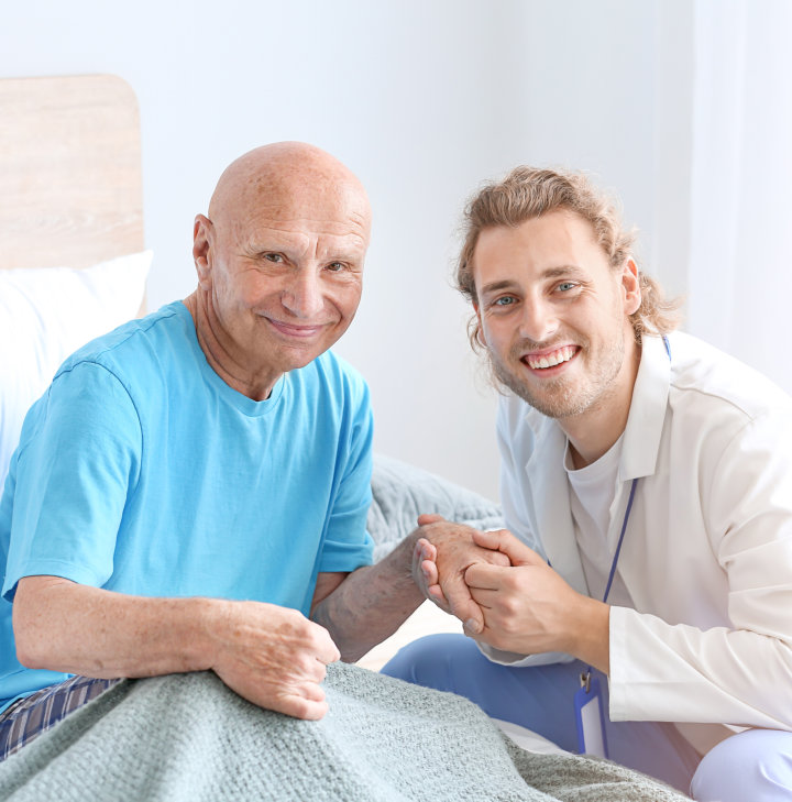 caregiver with senior on bed