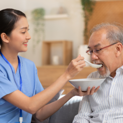 caregiver feeding senior