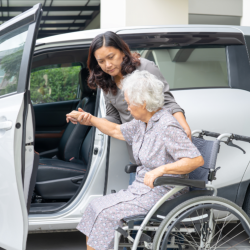 woman helping senior to ride vehicle