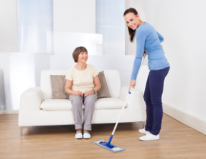 woman cleaning and senior sitting on couch